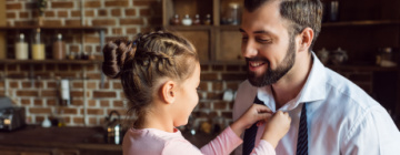 Litttle girl adjusting her daddy's tie as he gets ready for a job interview - call center jobs in Tijuana